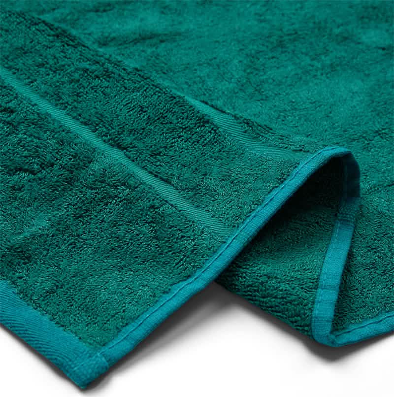 Et nærbillede af Bambooya Bambus badelagen (90 x 180 cm), pænt foldet for at fremhæve dens bløde, absorberende tekstur, fremstillet af OEKO-TECH Standard 100-certificeret stof.