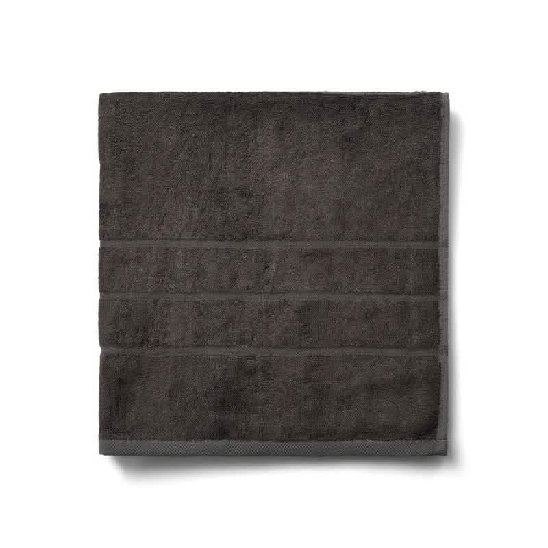 Et pænt foldet mørkegråt Bambooya Bambus badehåndklæde (70 x 140 cm) med tre syede linjer, fremstillet af økologisk bomuld og OEKO-TECH Standard 100-certificeret, vist på en hvid baggrund.