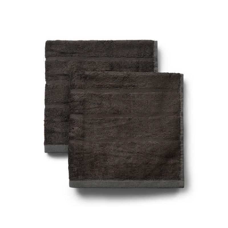 To pænt foldede Bambooya Bambus håndklæder (50 x 100 cm) i en pakke med 2 stk. med diskrete vandrette bånd er stablet side om side på en hvid baggrund.